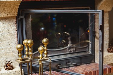 set of brass tools stands in front of fireplace