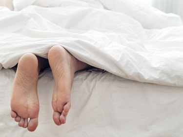 Lazy man and his feet ,  lying  on comfortable bed