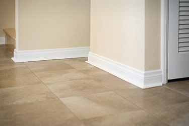 White baseboard along ceramic tile floor