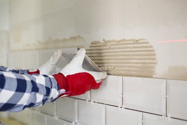 Process of tiling the tiles in the kitchen with necessary tiling tools. Home improvement, renovation concept