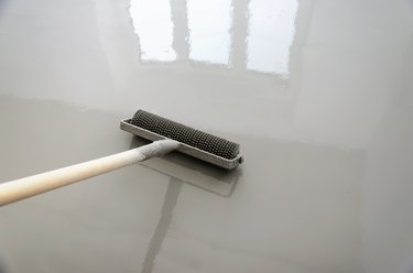 Self-leveling epoxy. Leveling with a mixture of cement floors with a roller
