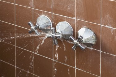 A shower faucet handle spraying leaking water