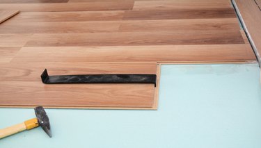 Install  wooden laminate flooring with insulation, tools and soundproofing sheets.