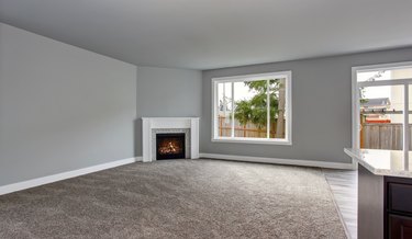 Grey house interior of living room with fireplace and carpet
