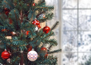Christmas tree with Christmas decoration near by winter frozen window
