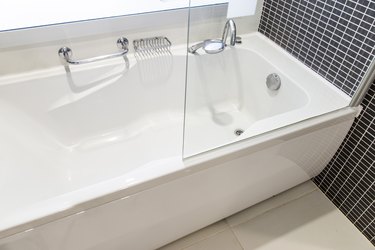 Bathtub with partial view of drain.