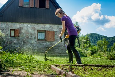 Woman Cutting  The Lawn  With  Weed  Trimmer