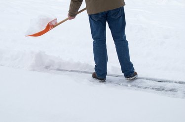 Low Section Of Man Removing Snow From Road