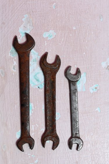 Wrenches for different sizes. Worn and covered with corrosion. Lie on the surface with peeling paint.