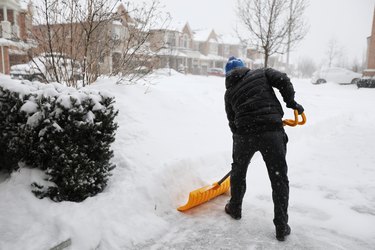 Man shoveling snow during snow storm in Toronto