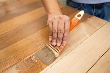 Applying protective varnish to wooden furniture.