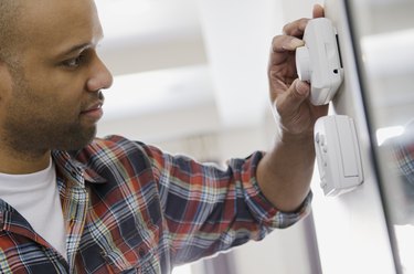 homeowner adjusting new thermostat