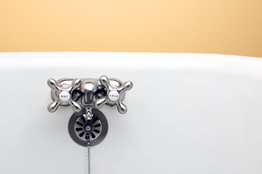 Porcelain Bathtub with Brushed Nickel Faucet and Orange Background