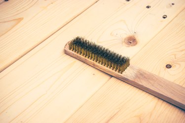 wire brush on wooden plank