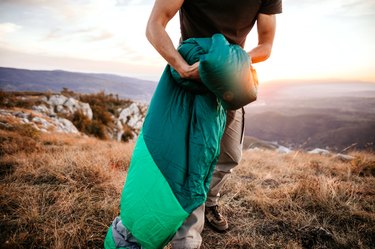 Sleeping bag being rolled up.