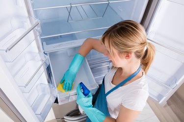 High Angle View Of Woman Cleaning Refrigerator