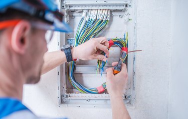 Close-Up Of Man Cutting Cables Against Wall