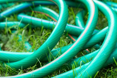 A green and orange hose for watering the garden close up