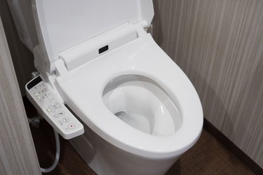 Modern high tech toilet with electronic bidet in Japan. Industry leaders recently agreed on signage standards for Japanese toilet bowls.