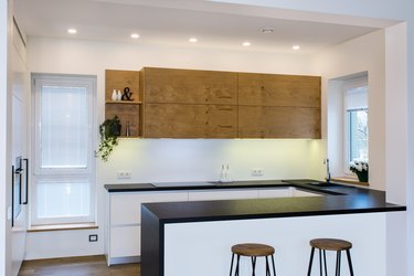Modern kitchen design in light interior with wood accents.