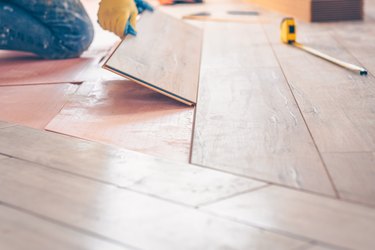 Professional installation of floor covering, the worker quickly and qualitatively mounts a laminate board