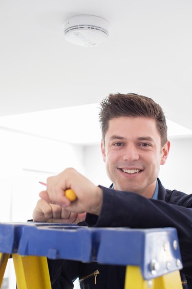 Man installing smoke alarm.
