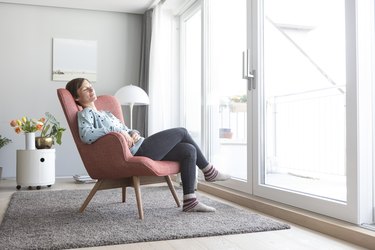 Woman relaxing on armchair at home