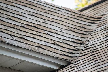 Damaged and old roofing shingles on a house.