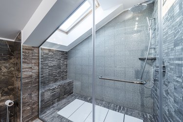 Glass shower cabin in modern loft bathroom.