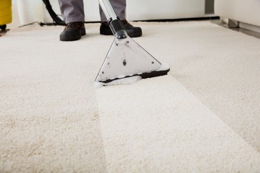 Person Cleaning Carpet With Vacuum Cleaner