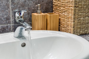 Bathroom sink with soap dispenser and toothbrushes container