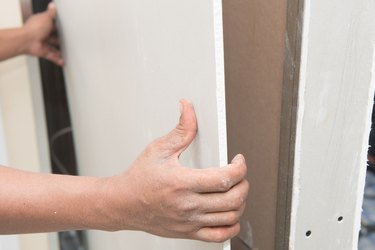 Construction worker holding gypsum board