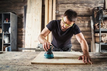 carpenter polishes wooden board
