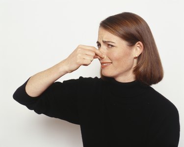 Young woman holding nose