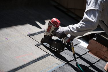 Installing new roof with nail gun