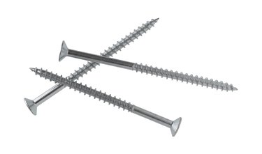 Long metal shelving screws on a white background.