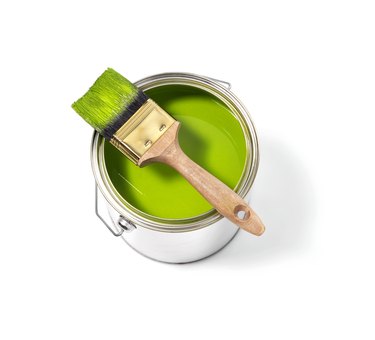 Green paint tin can with brush on top