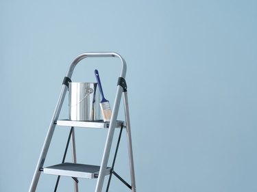 Stepladder holding paint can.
