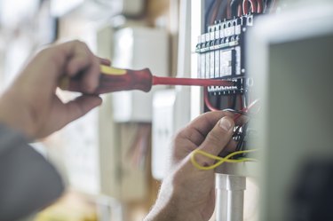 Electrician working on wired electrical board