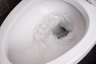 close up flushing water in toilet bowl.