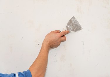 Painting worker repair wall using a paint spatula hand