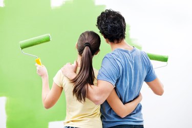 Young couple painting the wall.