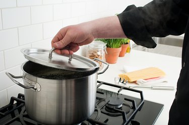 Man lifting lid on saucepan