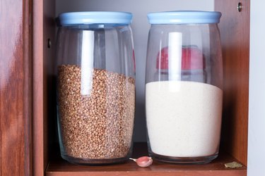 Glass jars with cereals in a kitchen cupboard. stocked kitchen pantry with food