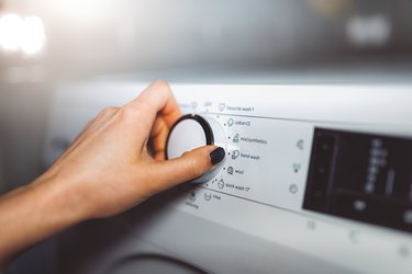 Woman choosing program on washing machine