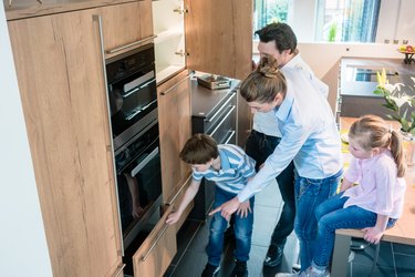 Scene in a kitchen showroom, family shopping for a new model