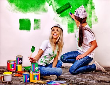 Woman paint wall at home