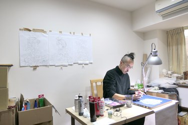 Artist Martin Hsu at his desk in his temporary studio in Taiwan