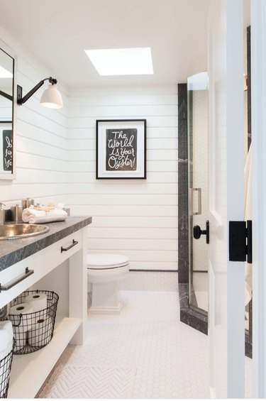 stainless drop in bathroom sink with white shiplap walls