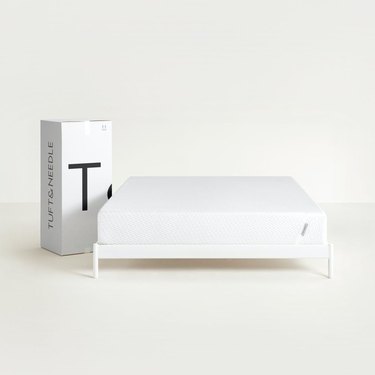 white cardboard box and bare mattress on bed frame
